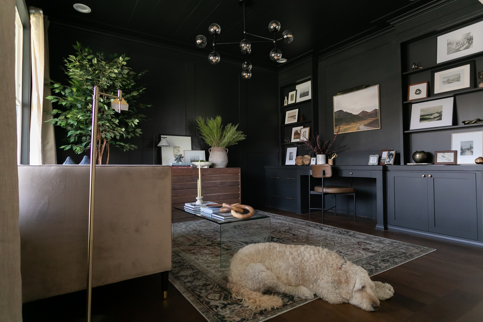 Dramatic home office with dark walls, built-in shelving, and globe chandelier — J. Arthur Custom Homes