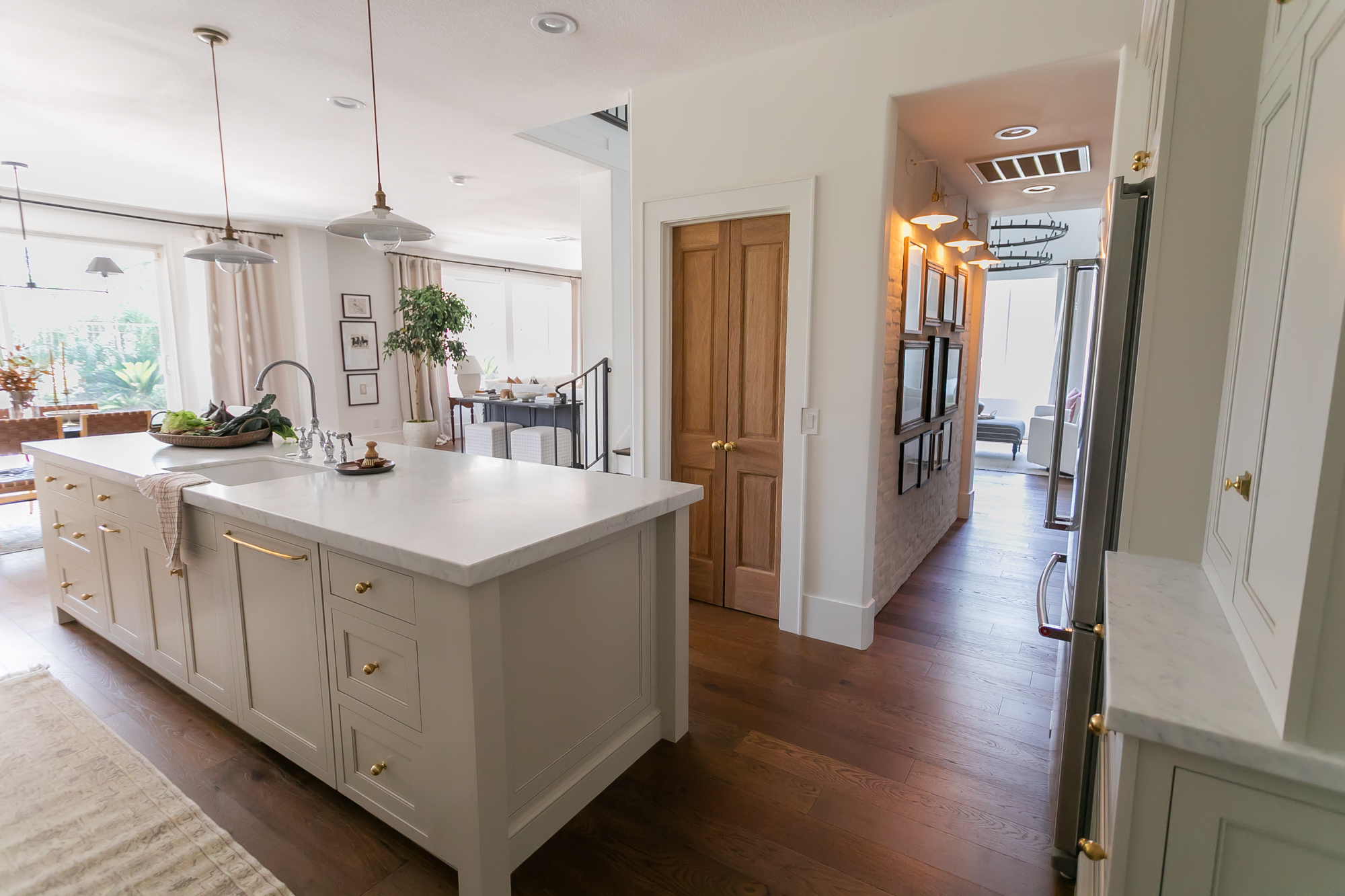 Custom kitchen island open to hallway with wood doors — J. Arthur Custom Homes Texas Hill Country
